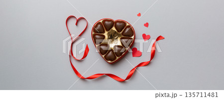 Delicious chocolate pralines in red box for Valentine's Day. Heart shaped box of chocolates top view with copy space Delicious chocolate pralines in red box for Valentine's Day. Heart shaped box of chocolates top view with copy space 135711481