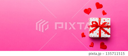Valentine day composition: red gift box with bow and heart. Christmas present. View from above. Space for text. Holday greeting card 135711515