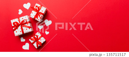 Valentine day composition: red gift box with bow and heart. Christmas present. View from above. Space for text. Holday greeting card Valentine day composition: red gift box with bow and heart. Christmas present. View from above. Space for text. Holday greeting card 135711517