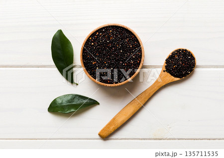 quinoa seeds in bowl and spoon on colored background. Healthy kinwa in small bowl. Healthy superfood 135711535