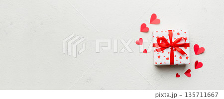 Valentine day composition: red gift box with bow and heart. Christmas present. View from above. Space for text. Holday greeting card Valentine day composition: red gift box with bow and heart. Christmas present. View from above. Space for text. Holday greeting card 135711667