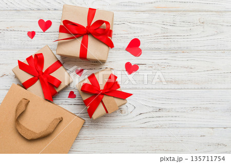 Gift boxes pop out from paper bag top view on colored background. bag packing handmade boxes fall out Concept of holidays, shopping, sale, discounts. Top view, flat lay 135711754