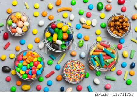 different colored round candy in bowl and jars. Top view of large variety sweets and candies with copy space 135711756