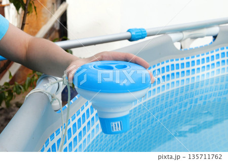 Worker hands isinfection and chlorination of water in the pool. Purification from pollution pool chlor dispenser Worker hands isinfection and chlorination of water in the pool. Purification from pollution pool chlor dispenser 135711762