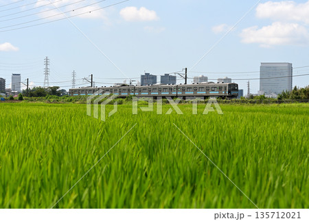 海老名駅周辺のビルを背に走る相模線 135712021