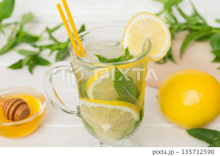 Mojito cocktail. Refreshing mojito cocktail with lime, lemon and mint in a tall glass with a stick 135712590