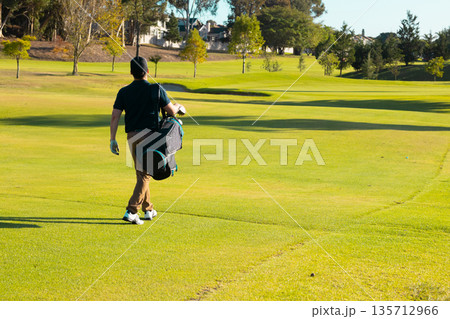 Male golfer walking across suburban golf fairway wearing polo shirt, carrying golf bag, copy space Male golfer walking across suburban golf fairway wearing polo shirt, carrying golf bag, copy space 135712966
