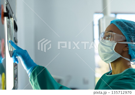 Midadult African American nurse reaching while interacting with touchscreen in hospital, copy space Midadult African American nurse reaching while interacting with touchscreen in hospital, copy space 135712970