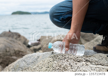 ペットボトルの水を持っている人 135713478