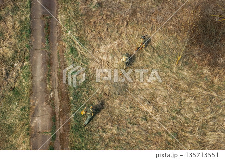 Men Dressed As US American Soldiers Of USA Infantry Of World War II sneaking around In spring Autumn Day. Soldiers prepare mortar for battle In dry grass. Aerial view elevated shot 135713551