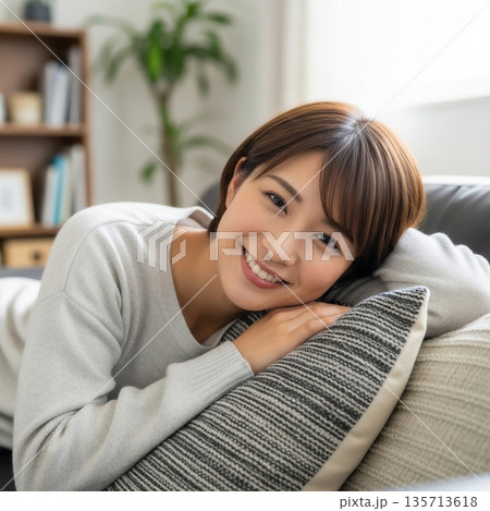 リビングのソファでくつろぐ若い女性 135713618