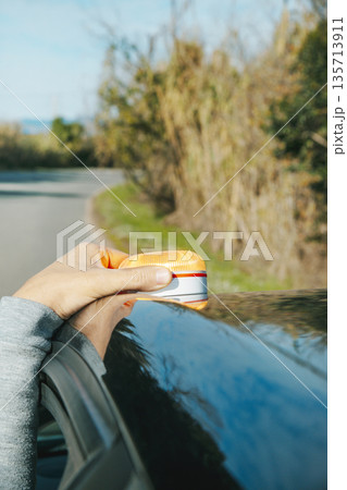 a man positioning a V16 warning beacon on a car 135713911
