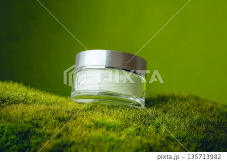A jar of white beauty cream in a container on green background. Cosmetic package mockup. Skin cosmetic product. 135713982