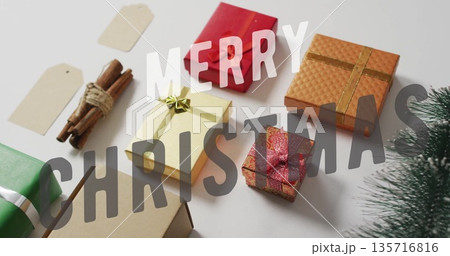 Merry Christmas text image over various wrapped gifts and holiday decorations Merry Christmas text image over various wrapped gifts and holiday decorations 135716816