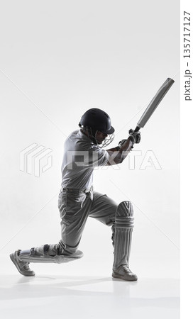 Cricket batsman kneeling power shot in studio isolated on white background. Cricket batsman kneeling power shot in studio isolated on white background. 135717127