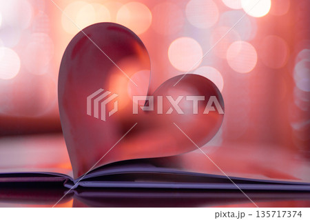 Red Valentines Day heart made from folded book pages, romantic warm bokeh lights background, panoramic banner and wallpaper decoration, dreamy love holiday design 135717374