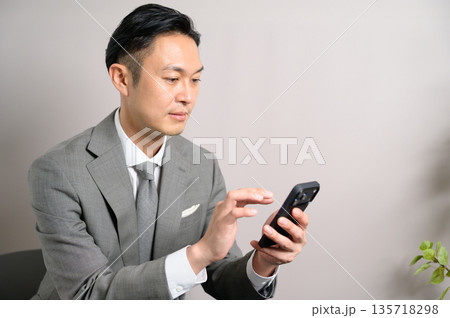 カフェで仕事をするスーツの男性 135718298