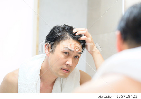 鏡で髪を気にする男性 鏡で髪を気にする男性 135718423