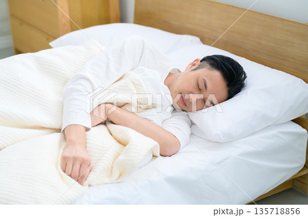 ベッドで眠る男性 135718856