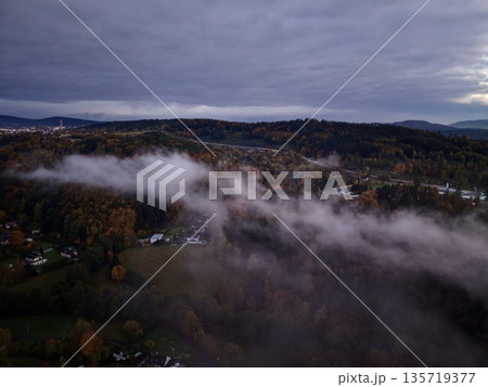 misty landscape view, foggy valley with muted hues, thick fog cascading over rooftops and trees misty landscape view, foggy valley with muted hues, thick fog cascading over rooftops and trees 135719377