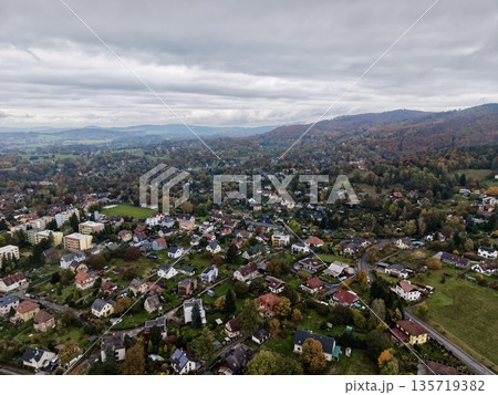 beautiful fall tableau featuring vibrant leaves on gentle hills with scattered residences nearby beautiful fall tableau featuring vibrant leaves on gentle hills with scattered residences nearby 135719382