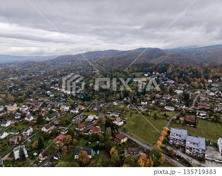 village amidst rolling green hills, pastoral landscape with scattered dwellings and distant ridgelines 135719383