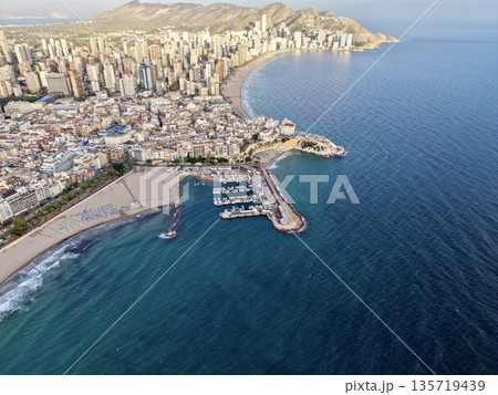 seaside port scene, harbor view with promenade, coastal bay featuring piers and sunlit facades 135719439