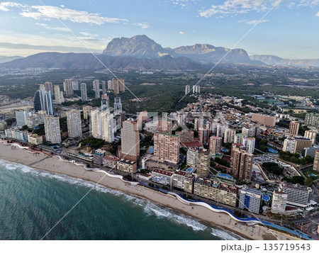 vibrant mountain resort scene, lush hillside urban area with shoreline capturing lively vacation ambiance 135719543