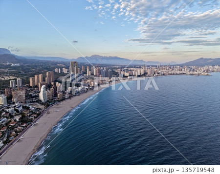 picturesque shoreline featuring highrise structures and generous stretch of golden sands under serene sky picturesque shoreline featuring highrise structures and generous stretch of golden sands under serene sky 135719548
