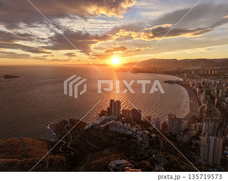 sunset bay tranquility, dusk illuminates coastal landscape featuring tranquil waters and distant towers sunset bay tranquility, dusk illuminates coastal landscape featuring tranquil waters and distant towers 135719573