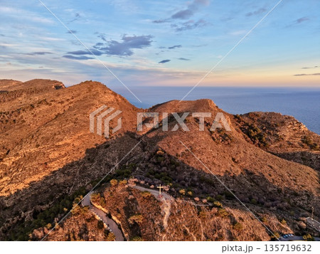 serene hillside surrounded by nature, mighty promontory overlooking tranquil waters beneath glowing sunset serene hillside surrounded by nature, mighty promontory overlooking tranquil waters beneath glowing sunset 135719632