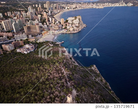 cityscape meets nature, metropolitan outskirts adjoin verdant cliffs and tranquil shoreline scene 135719671