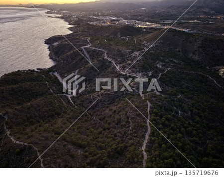 hiking along rugged seaside cliffs, exploring wild shoreline with breathtaking sunset and cliffs 135719676