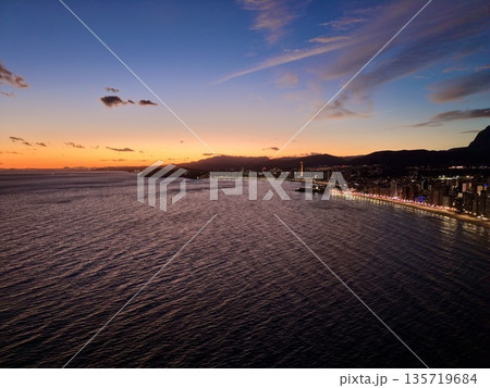 peaceful sunset over quiet water harbor, tranquil bay viewed from above with boats and glowing shoreline peaceful sunset over quiet water harbor, tranquil bay viewed from above with boats and glowing shoreline 135719684