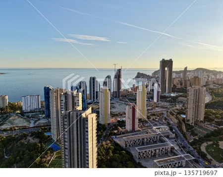 coastal skyscrapers under evening sky, bright horizon with ships and highrise buildings at dusk coastal skyscrapers under evening sky, bright horizon with ships and highrise buildings at dusk 135719697