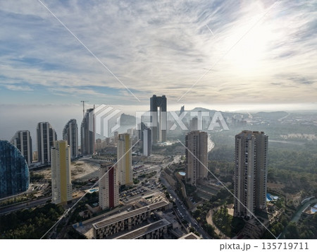 urban sunrise vista, bright hillside with foggy valley, morning glow over city with green spaces 135719711
