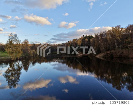 water mirrors sky, capturing broad perspective of bright sky reflected on tranquil lake surface 135719802