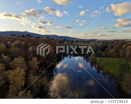 beautiful twilight scene with gentle reflections of clouds and distant golden horizon glow 135719810