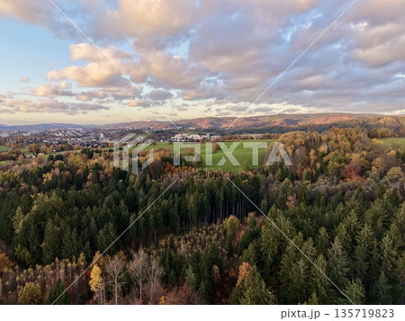 vast woodland with village views, rolling hills accentuated by warm sunset and shadow play vast woodland with village views, rolling hills accentuated by warm sunset and shadow play 135719823