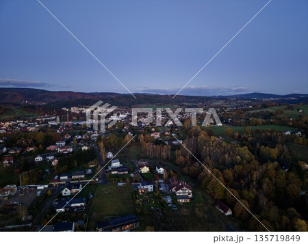 sunset hillside vista, evening landscape with distant peaks, dusk views over residential mountainside terrain 135719849