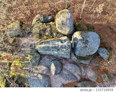 granite boulders in forest, closeup of textured granite and mossy boulders illuminated by warm sunlight 135719859