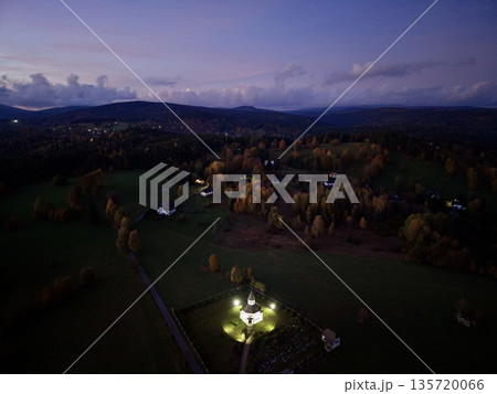 calm rural landscape featuring lit cottage amid shadowed meadows and wooded hills at twilight calm rural landscape featuring lit cottage amid shadowed meadows and wooded hills at twilight 135720066