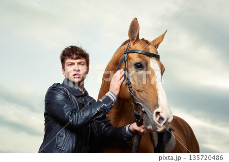 A man hugs a horse outdoors 135720486