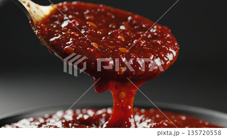 Thick Red Sauce Pouring from Spoon Cooking Detail 4k ai 135720558