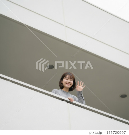ベランダから手を振る若い女性 135720997
