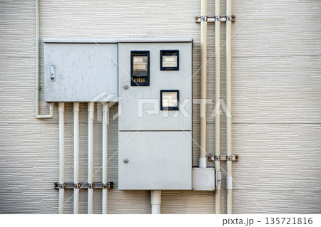 集合住宅の外壁の電気メーターボックスと配管 集合住宅の外壁の電気メーターボックスと配管 135721816
