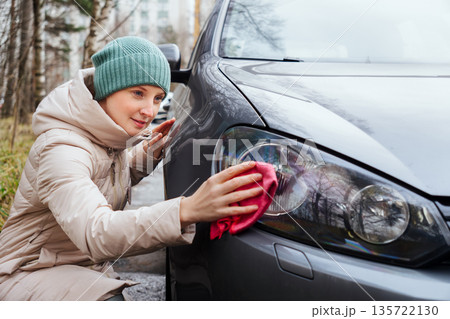 A woman washes her car A woman washes her car 135722130
