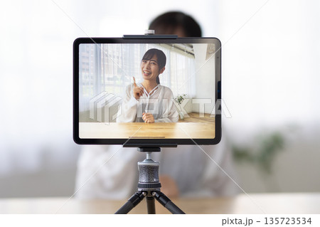 タブレットを使ってライブ配信をする若い女性 タブレットを使ってライブ配信をする若い女性 135723534