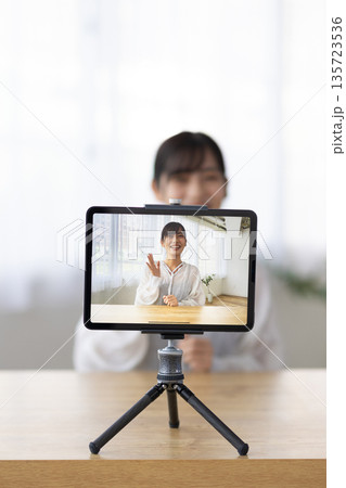 タブレットを使ってライブ配信をする若い女性 135723536