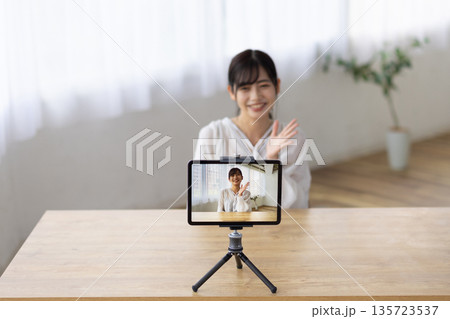 タブレットを使ってライブ配信をする若い女性 タブレットを使ってライブ配信をする若い女性 135723537